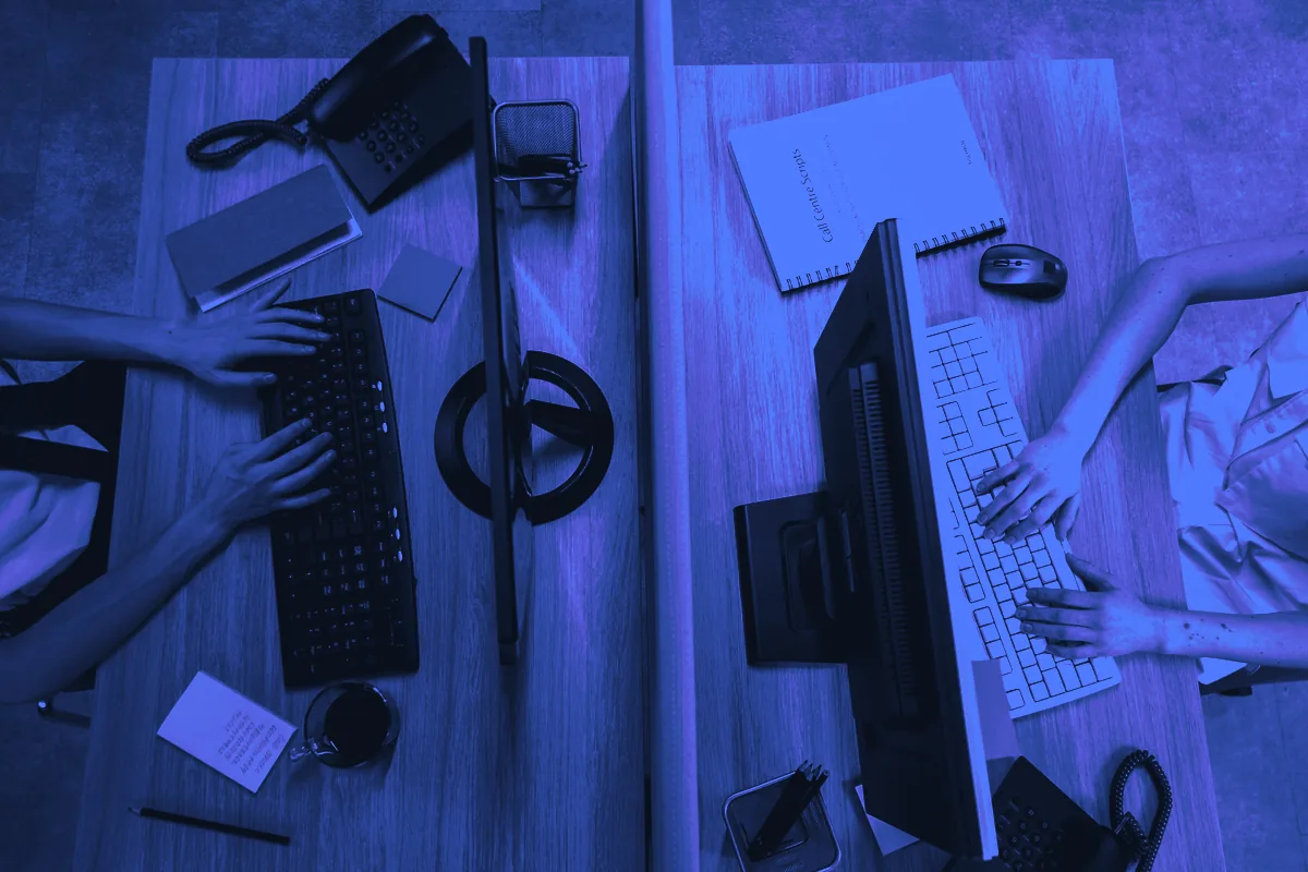 Deux postes de travail vus du dessus avec clavier, téléphone fixe et script d’appel : une force de vente sédentaire