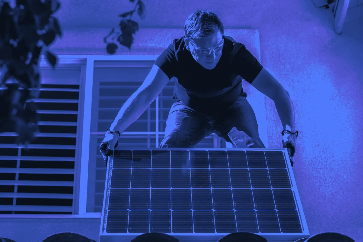 Installateur posant un panneau photovoltaïque sur une toiture en tuiles, chantier type des leads panneaux solaires