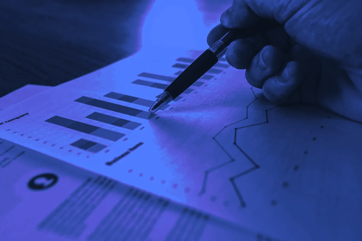 Stylo pointant un graphique en barres sur un document d’analyse, pour estimer le prix d’un lead qualifié